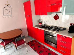 a kitchen with red cabinets and a table and a stove at Room La Vicenna in Scanno