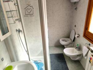 a bathroom with a shower and a toilet and a sink at Room La Vicenna in Scanno