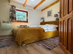 sypialnia z łóżkiem i oknem w obiekcie Domek pod Świerkami w Jeleniej Górze