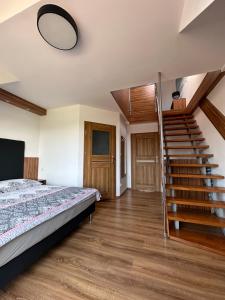 ein Schlafzimmer mit einem Bett und einer Wendeltreppe in der Unterkunft Holiday Amber - in Niechorze