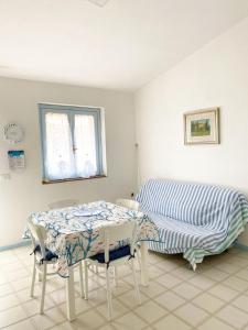 a dining room with a table and a bed at Casa Borghi - Villaggio Oasy San Tedoro in San Teodoro