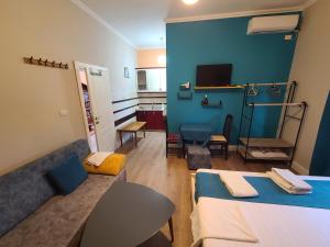 uma sala de estar com um sofá e uma parede azul em My Apartments Durres em Durrës