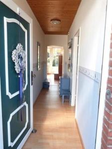 einen Flur mit einer Tür, die zu einem Zimmer führt in der Unterkunft Ferienhaus in Berumbur mit Garten, Terrasse und Grill - b48547 in Berumbur