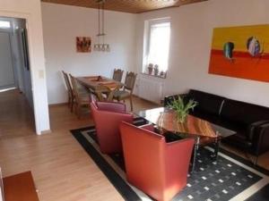 ein Wohnzimmer mit einem Sofa, einem Tisch und Stühlen in der Unterkunft Ferienhaus in Berumbur mit Garten, Terrasse und Grill - b48547 in Berumbur