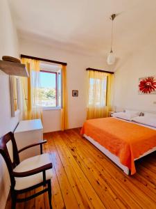 a bedroom with a bed and a chair and a window at Apartments Lukrecia in Hvar