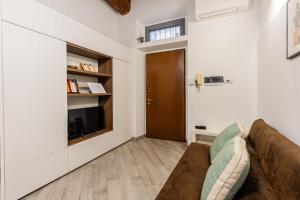 a living room with a couch and a television at Homeby, Loft Anna Maria in Corsico