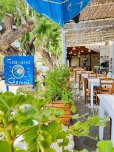 un ristorante con tavoli e sedie e un cartello blu di Gerani Studios a Astypalaia Town