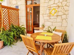 a wooden table and chairs on a patio at Apartments Lukrecia in Hvar