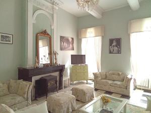 sala de estar con chimenea y espejo en Le Manoir, en Capestang