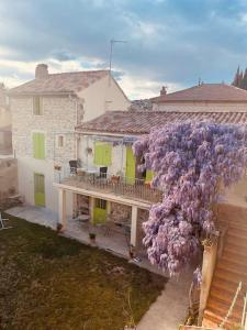 a house with a bunch of purple flowers on the side of it at Maison provençale les glycines in Roquemaure