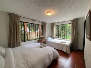 - une chambre avec 2 lits et de grandes fenêtres dans l'établissement Casa Campestre Villa Cecilia, à Villa de Leyva