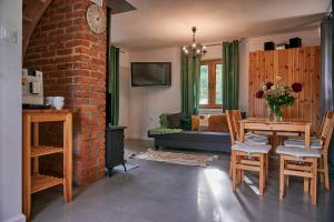 a living room with a table and a brick wall at Slow Orzechów in Sosnowica