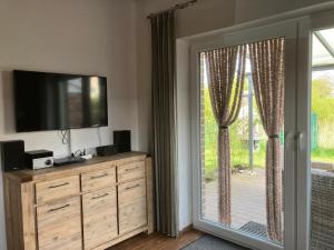 TV a/nebo společenská místnost v ubytování Ferienhaus in Dorumer Neufeld mit Grill, Garten und Terrasse