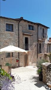 an umbrella in front of a stone building at Il Borgo della Zittola in Montenero Val Cocchiara
