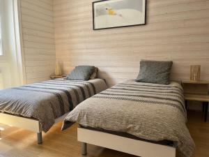 two beds sitting next to each other in a bedroom at Guimbert'Home in Le Bourg-dʼOisans
