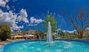 a fountain in a park with a blue sky at Suzy's nest room in Asprovalta