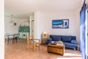 un soggiorno con divano blu e tavolo di la casa di iuri a Punta Secca
