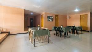 a dining room with green tables and chairs at RedDoorz at Elegance Guest House near NAIA T3 in Manila
