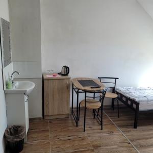 Habitación con lavabo, mesa y cama en Pokoje en Tczew