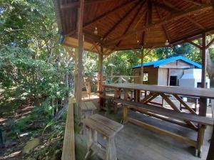 a wooden pavilion with a picnic table and a dog house at Ti Paradis Gîte à 200 m plage de Grande Anse in Deshaies +3 photos