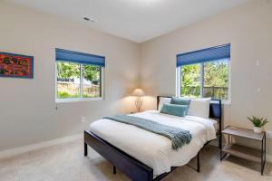 a bedroom with a large bed and two windows at Spacious Eagle Home with Hot Tub in Eagle