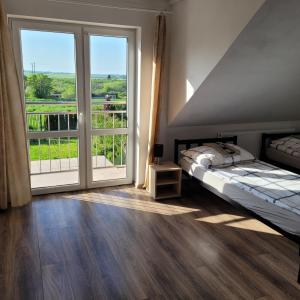 1 dormitorio con cama y ventana grande en Pokoje en Tczew