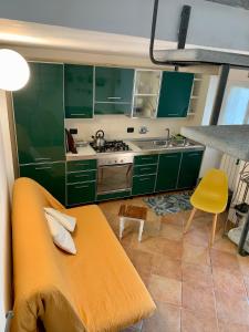 una cocina con armarios verdes y un banco amarillo en La Casa di Sandra a Noli en Noli