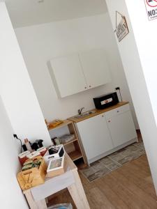 a kitchen with white cabinets and a table at Vama House in Naples