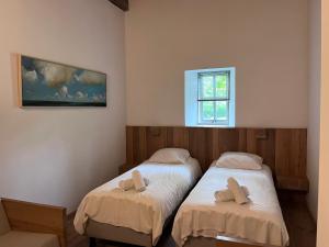 2 łóżka pojedyncze w pokoju z oknem w obiekcie erfgoed Rikkerda w mieście Lutjegast