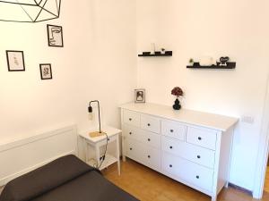 a bedroom with a bed and a white dresser at Purple House - Arboriamar Platamona in Sorso
