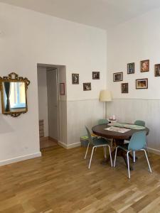 Un comedor con una mesa y sillas y un espejo. en La casa di Remo, en Roma