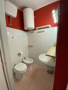 Un baño con un inodoro blanco y un lavabo. en La casa di Remo, en Roma 15 fotos más