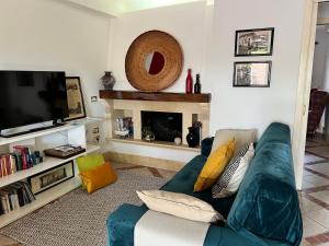 ein Wohnzimmer mit einem blauen Sofa und einem TV in der Unterkunft la casetta tra la laguna e il mare Poetto in Cagliari