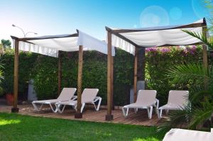 a gazebo with white chairs on a wooden deck at Hotel Oasis in Córdoba