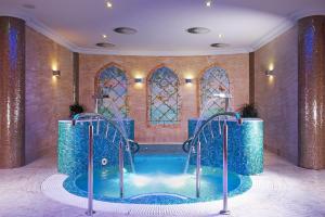 a spa room with a plunge pool and stained glass windows at Retro Riverside Wellness Resort in Karlovy Vary