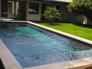 a swimming pool with blue water in a yard at Chambres d'Hôtes En Aparté in Toulouse