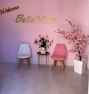 two chairs and a sign on a wall with flowers at Bella Vista in Balíon