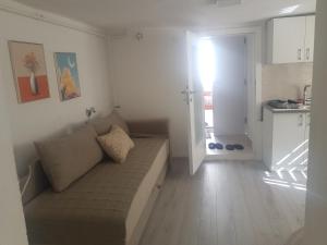 a living room with a couch and a kitchen at Apartman Memo in Sarajevo