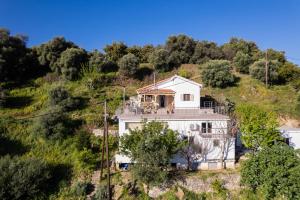 a white house on a hill with trees at Iris Cretan Mountain Escape in Apothíkai