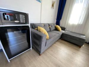 ein Wohnzimmer mit Couch und Mikrowelle in der Unterkunft Acer Güneş Otel in Didim