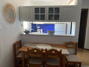 a kitchen with a wooden table and chairs and a kitchen counter at Irini Seaside Apartment in Paleo Tsifliki
