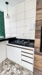 uma cozinha com uma placa de fogão numa cozinha branca em Casa em Ubajara em Ubajara