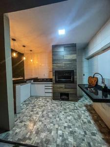 uma cozinha com armários brancos e piso em azulejo em Casa em Ubajara em Ubajara