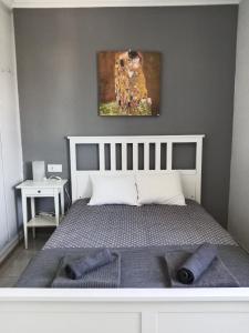Un dormitorio con una cama con un cuadro en la pared. en Top Home Jasmine Jerez, en Jerez de la Frontera