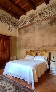 a bedroom with a large bed with white sheets at Palazzo Pirro Dimora Storica in Acciano
