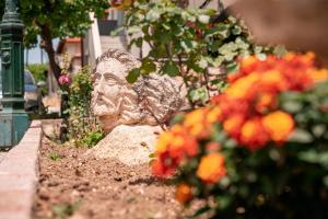 um jardim com flores e uma estátua de pedra em Sante em Kallithea Halkidikis