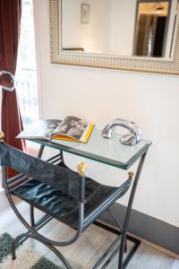- un bureau en verre avec un livre à côté d'un miroir dans l'établissement Villa Vichéia - Appartement 13, à Vichy