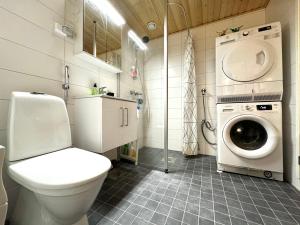 a bathroom with a toilet and a washing machine at Sleep and fly room - Homestay in Vantaa