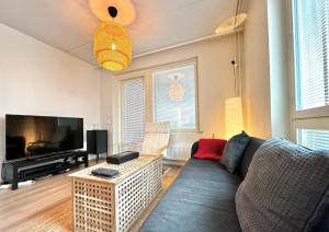 a living room with a couch and a flat screen tv at Sleep and fly room - Homestay in Vantaa