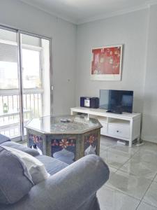 Una sala de estar con un sofá, una mesa y un televisor. en Top Home Jasmine Jerez, en Jerez de la Frontera